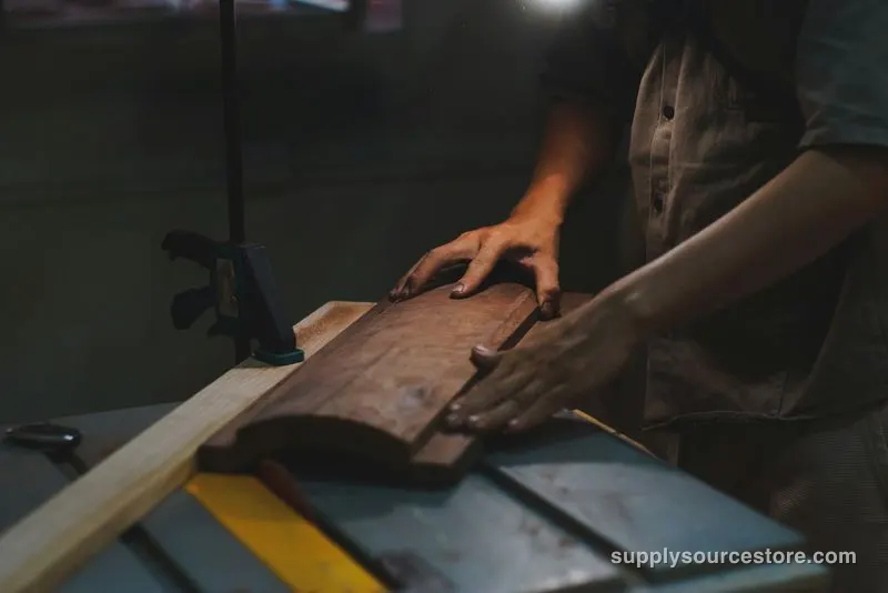 Carpenter guiding a board through a table saw